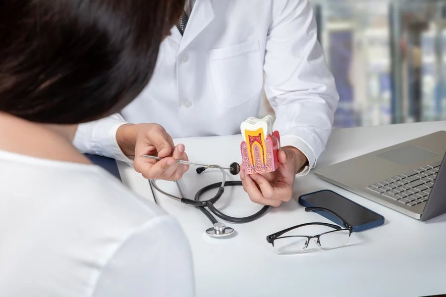 Endodontist explains the root canal procedure to a female patient